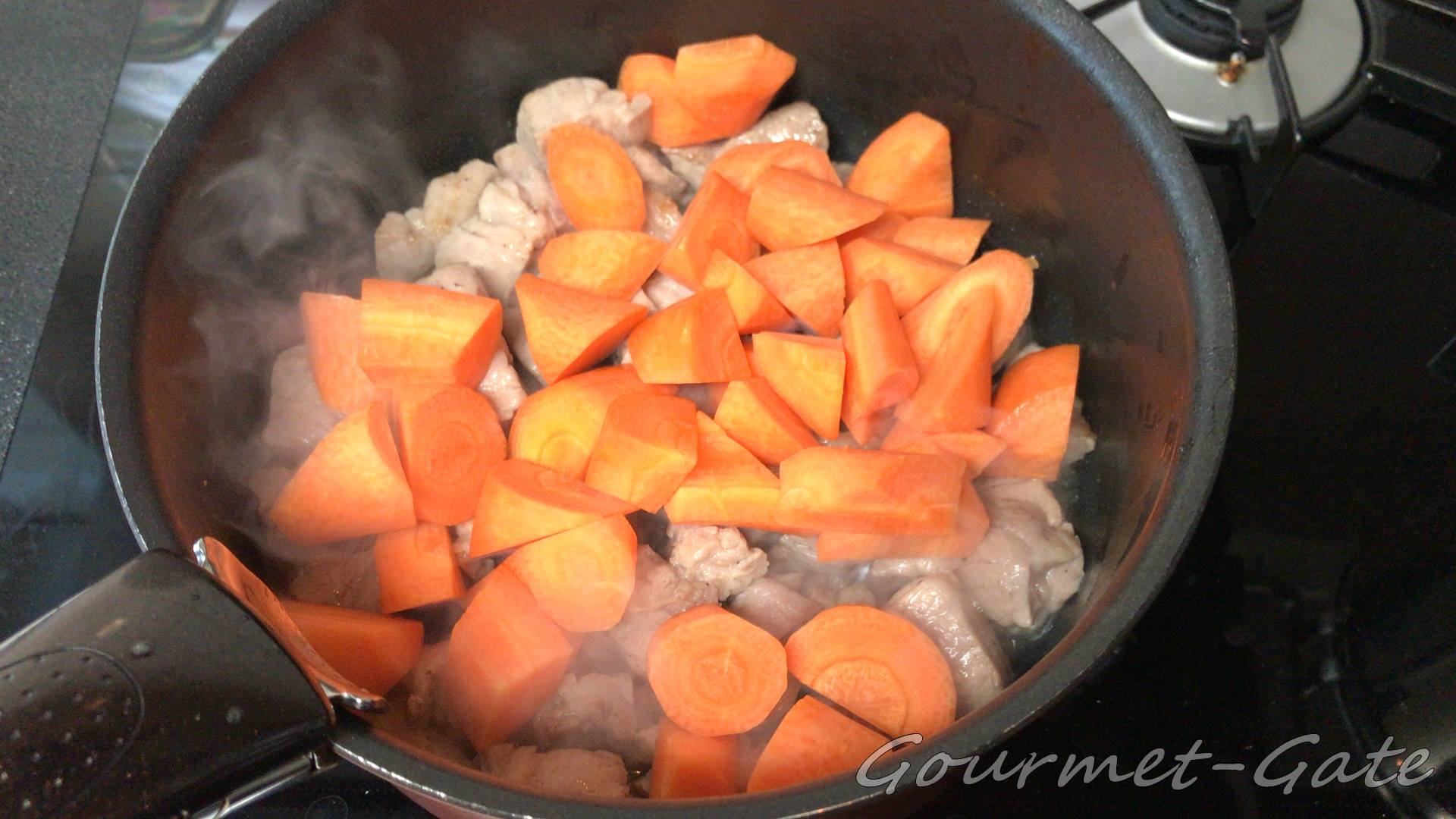 肉を炒めてから人参を加えてカレー作り
